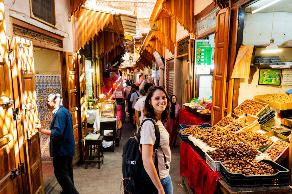 Reiziger in de medina van Marrakech langs kraampjes met dadels en noten tijdens de Route Marokko.