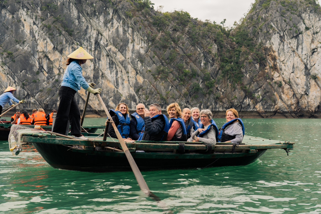 Reizigers varen en poseren voor foto bij Lan Ha Bay in Vietnam