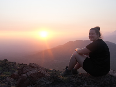 Reiziger geniet van zonsondergang op een bergtop langs de Pan-American Highway, Route Trans Midden Amerika.