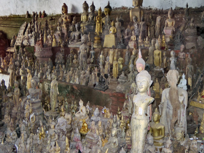 Verzameling Boeddhabeelden en -beeldjes in een tempelgrot in Thailand, Laos of Cambodja.