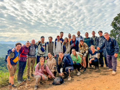 Groepsfoto van 22-35ers tijdens een hike met uitzicht op groene bergen in Thailand, Laos en Cambodja.