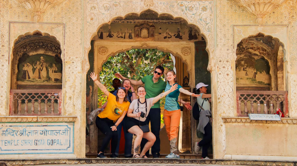 Reizigers poseren in een boogpoort bij Temple Shri Gyan Gopal Ji tijdens groepsrondreis Noord-India.